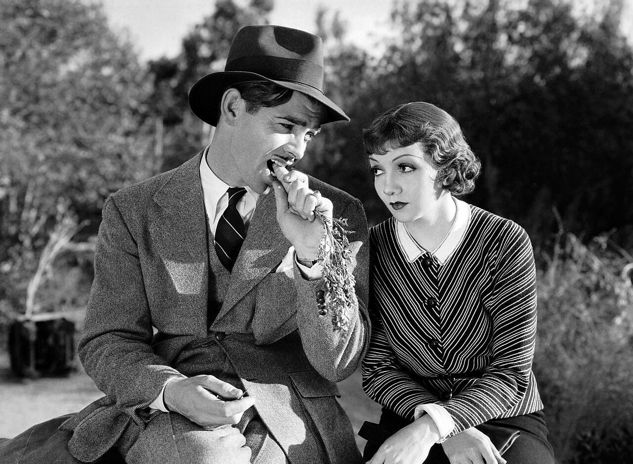 Clark Gable and Claudette Colbert together in a black-and-white publicity still for It Happened One Night.