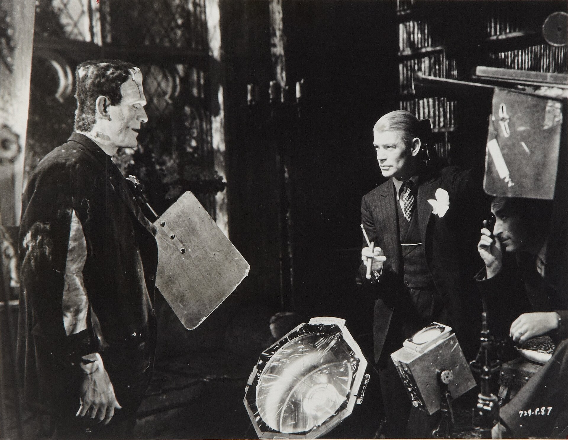 Boris Karloff in monster make-up stands with James Whale and John J. Mescall on the set of Bride of Frankenstein.