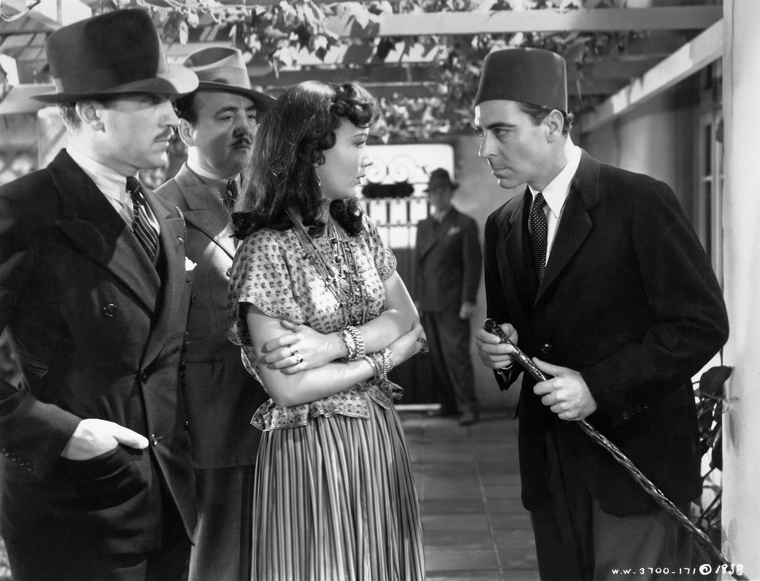Hedy Lamarr and Charles Boyer standing with other actors in a scene from Algiers.