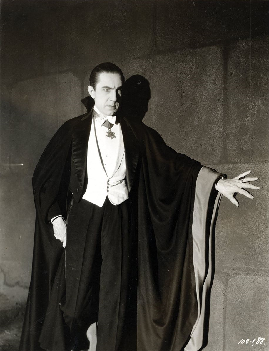 Bela Lugosi wears evening clothes and a cape as Count Dracula in a black-and-white Universal publicity portrait.