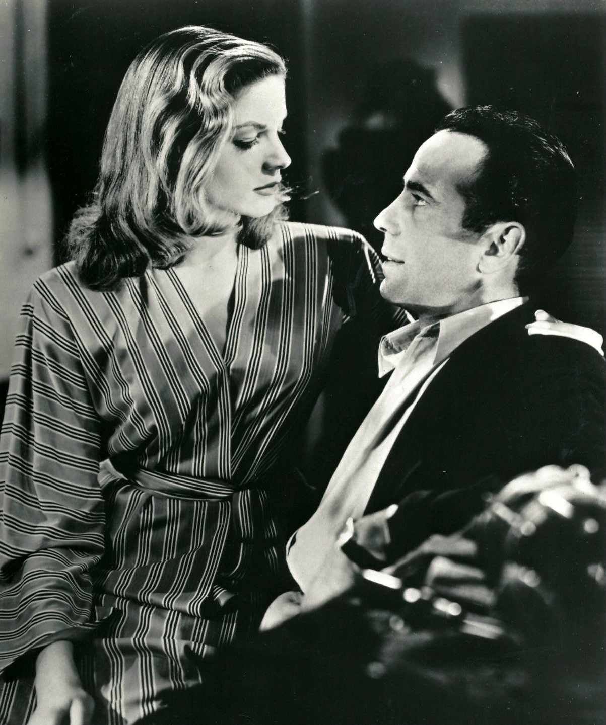 Humphrey Bogart and Lauren Bacall facing one another in a black-and-white publicity image for To Have and Have Not.