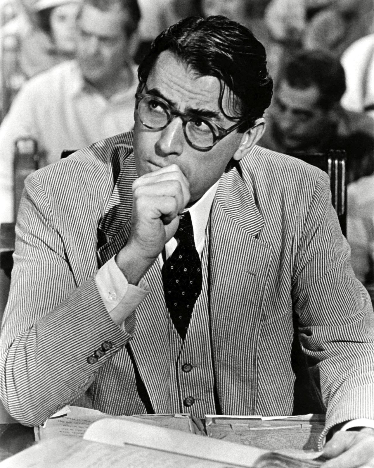 Gregory Peck wears a dark suit and waistcoat as Atticus Finch in a publicity portrait for To Kill a Mockingbird.