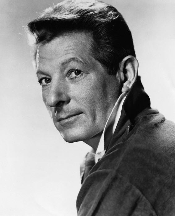 Danny Kaye smiles towards the camera in a black-and-white studio publicity portrait.