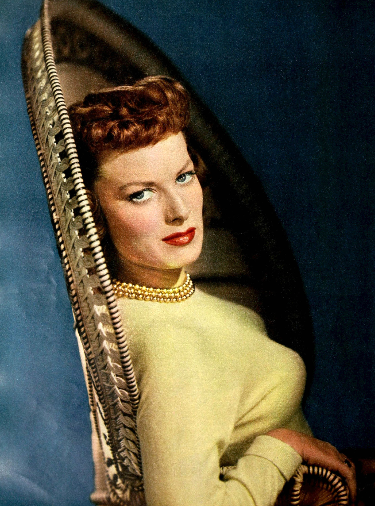 Maureen O’Hara smiles towards the camera in a black-and-white magazine portrait from 1950.
