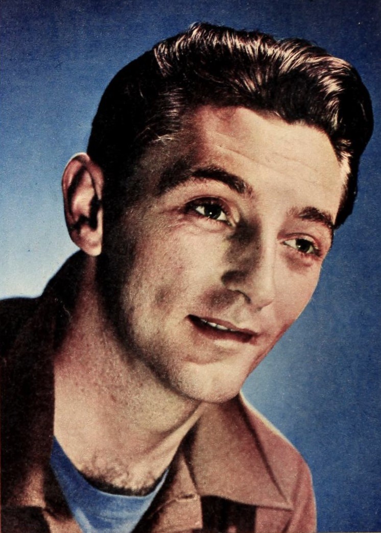 Black-and-white studio portrait of Robert Mitchum wearing a suit and looking towards the camera in 1946.